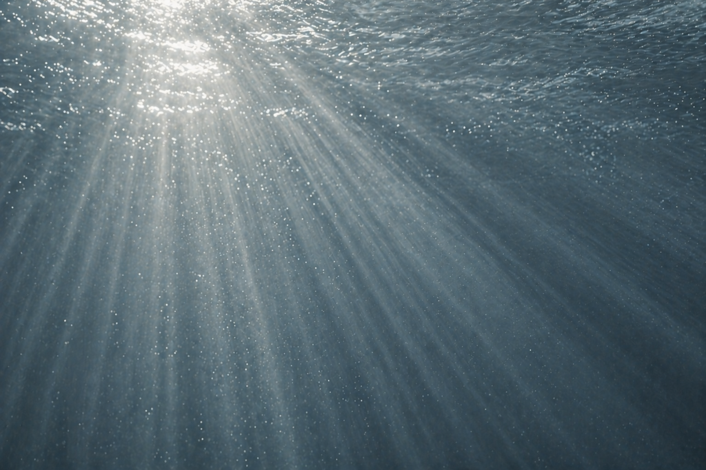 Rayons de lumière diffractés à travers l'eau bleue, symbolisant l'unité invisible et la source commune de la communion